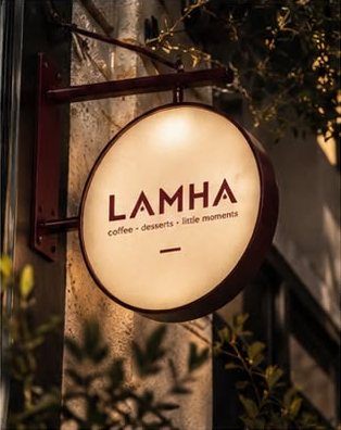 Round illuminated LAMHA sign hanging from a burgundy bracket