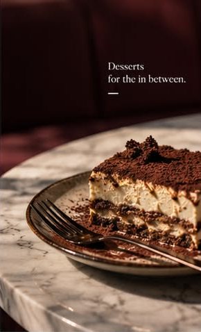 A slice of tiramisu on a marble table, dusted with cocoa